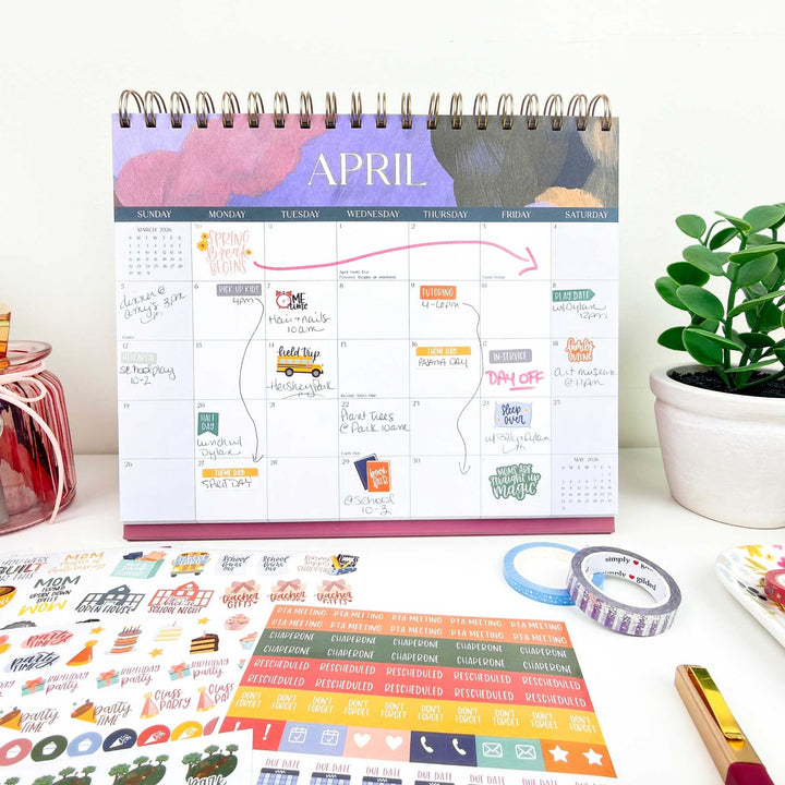 Monthly planner with stickers and tape on a desk