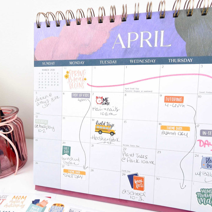 April calendar with colorful notes and events on a white surface