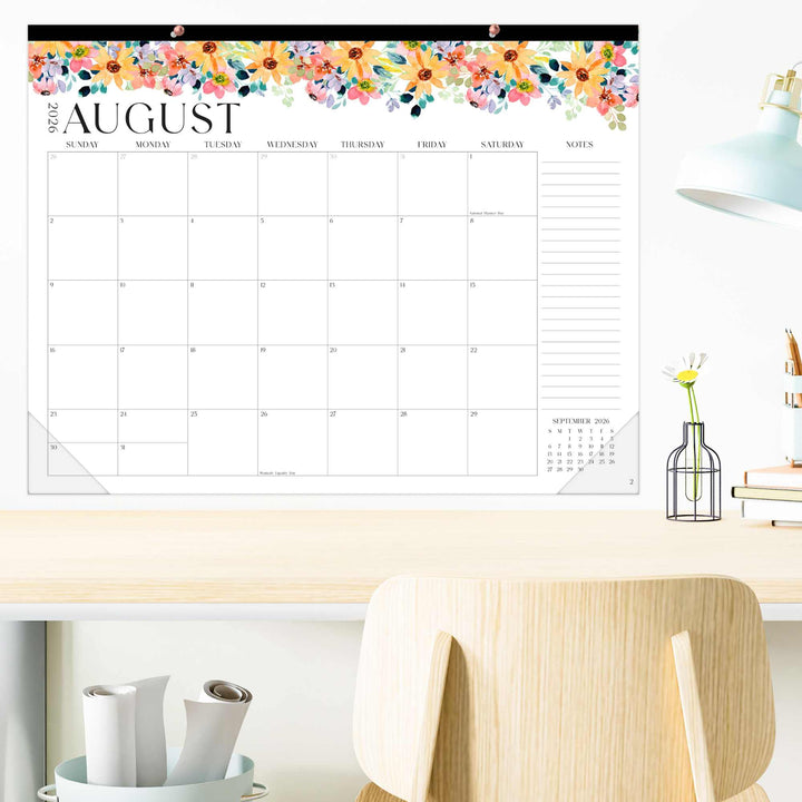 Wall calendar with floral design on a desk