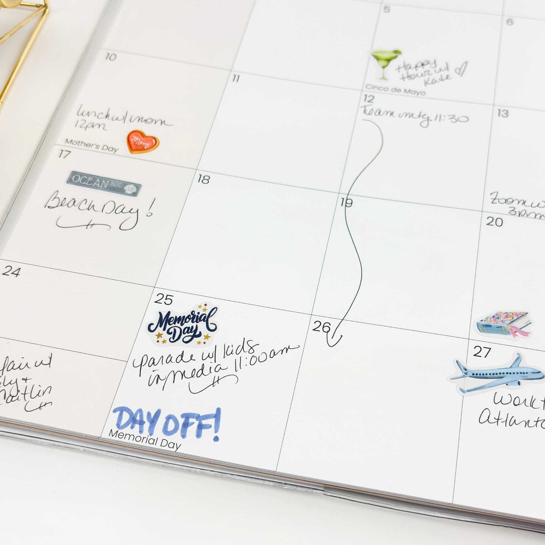 Close-up of May calendar showing Memorial Day and travel stickers in use