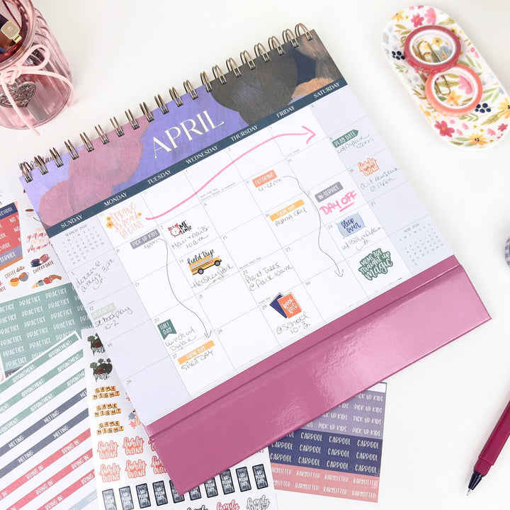 April planner with stickers and a pen on a white surface