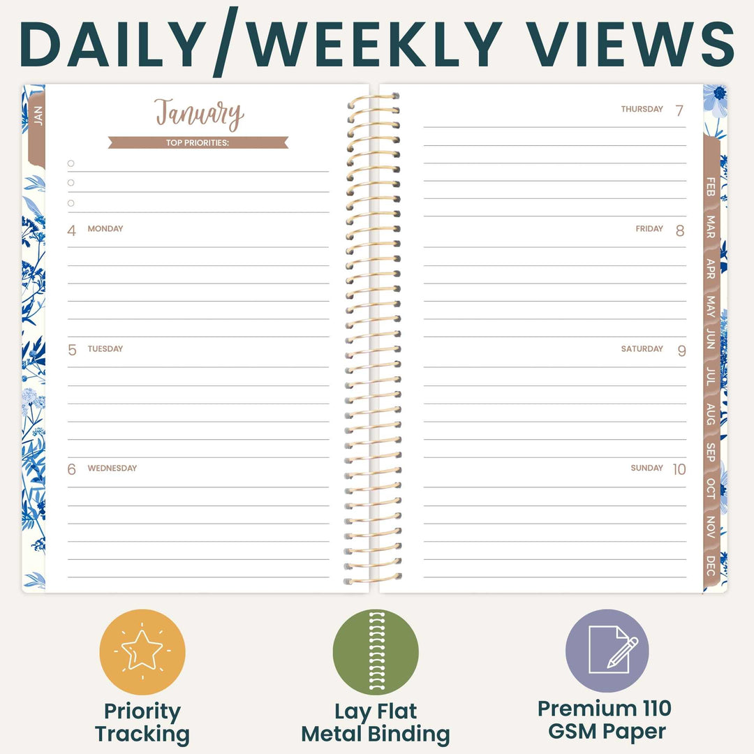 An open spiral-bound planner shown on a light beige background with the headline 'DAILY/WEEKLY VIEWS' at the top. The planner page is labeled January and includes columns for Monday through Sunday, with decorative blue floral borders and a tan vertical header strip.