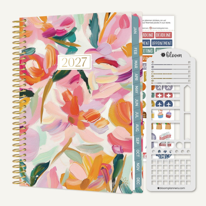 A 2027 spiral-bound planner with a colorful floral watercolor cover, shown with a white sticker sheet and planner inserts on a light beige background. The brand name 'bloom planners' is visible on the sticker sheet.