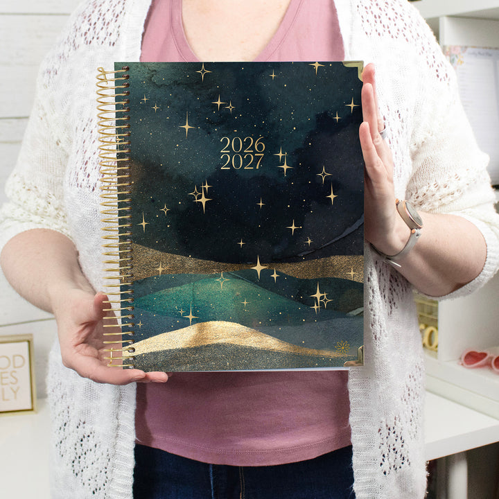 Person holding a 2026-2027 planner with star design