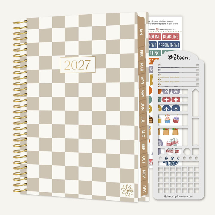 A 2027 spiral-bound planner with a beige and white checkerboard cover, shown alongside a sheet of colorful planner stickers and a white plastic sticker organizer tool on a light gray background.