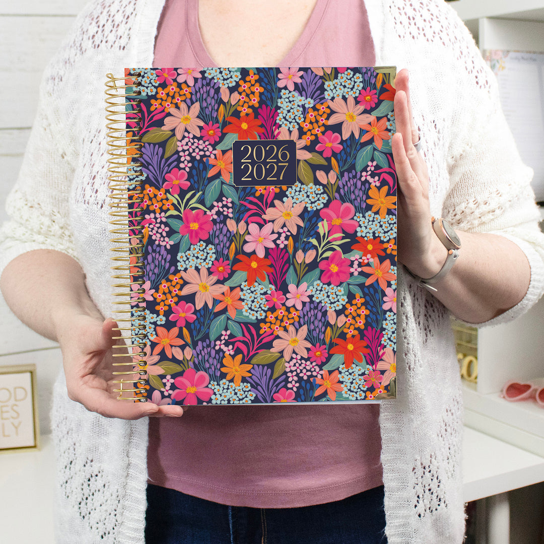 Person holding a floral planner with 2026-2027 date range