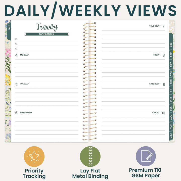 An open spiral-bound planner shown from the daily views page, with lined sections for Monday through Sunday and floral side borders. Large text at the top reads 'DAILY/WEEKLY VIEWS,' and three feature icons and labels at the bottom mention priority tracking, lay flat metal binding, and premium 110 GSM paper.
