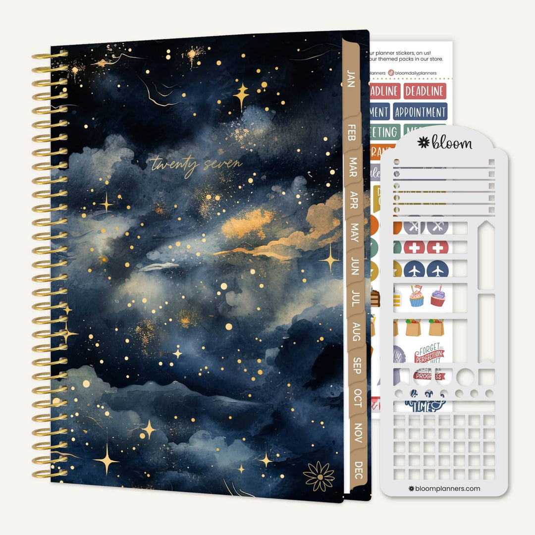 A spiral-bound planner or notebook with a dark navy and black starry sky cover, shown alongside a white sticker sheet and a vertical tab labeled bloom.