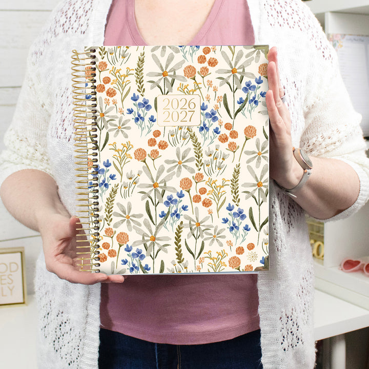 Person holding a 2026-2027 floral planner