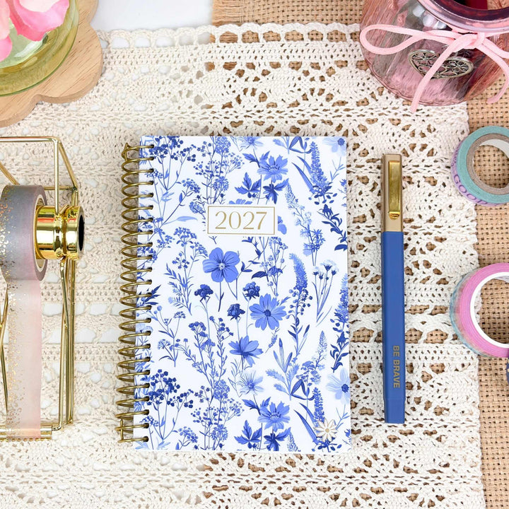 Blue & White floral design pocket planner on a styled desk with pretty accessories.