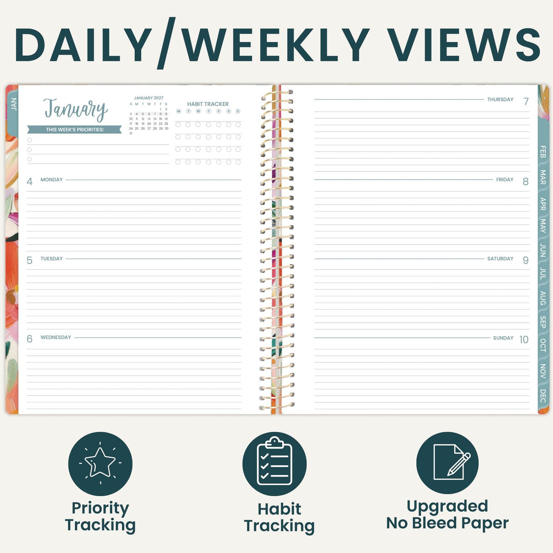 An open planner shown from above with the heading 'DAILY/WEEKLY VIEWS' at the top and three feature icons below: priority tracking, habit tracking, and upgraded no bleed paper. The planner pages are mostly white with teal and multicolor printed sections and a spiral binding.