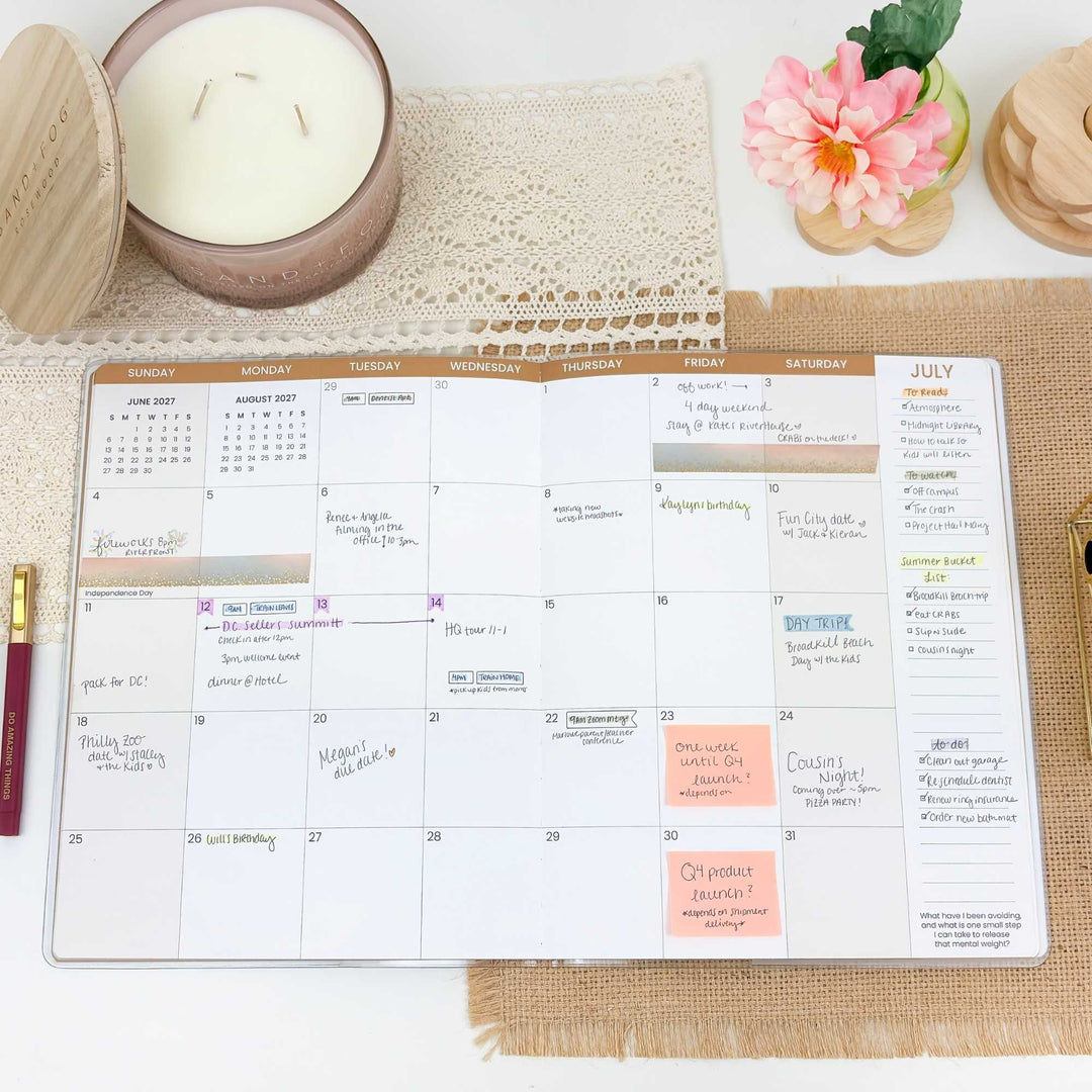 Calendar on a table with a candle and flowers in the background