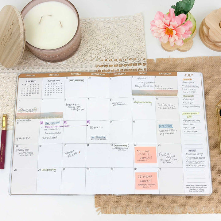 Calendar on a table with a candle and flowers in the background