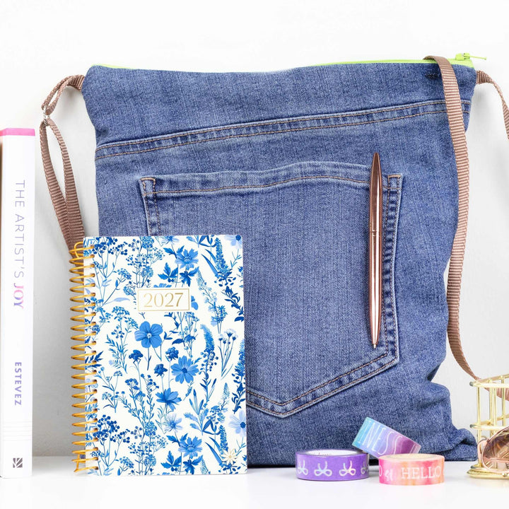 A pocket planner next to a purse to show the small scale.