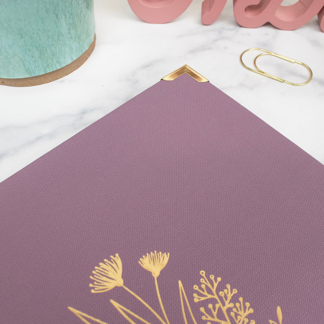 Purple mat with gold floral designs on a white surface