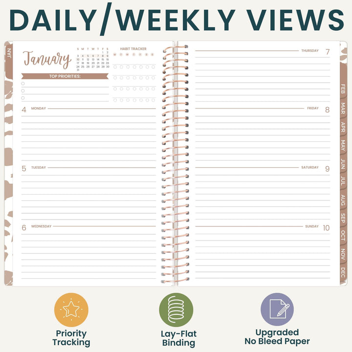 An open spiral-bound planner shown on a light beige background with the heading 'DAILY/WEEKLY VIEWS' at the top. The planner page includes sections for Monday through Sunday, a January calendar, habit tracker boxes, and vertical tabs labeled by month.