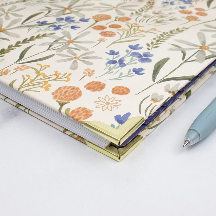 Floral-patterned notebook with a pen on a white background