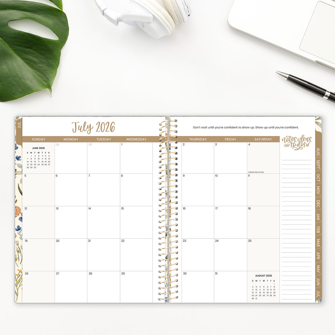 Spiral-bound planner open to July 2026 with a pen and plant on a white surface