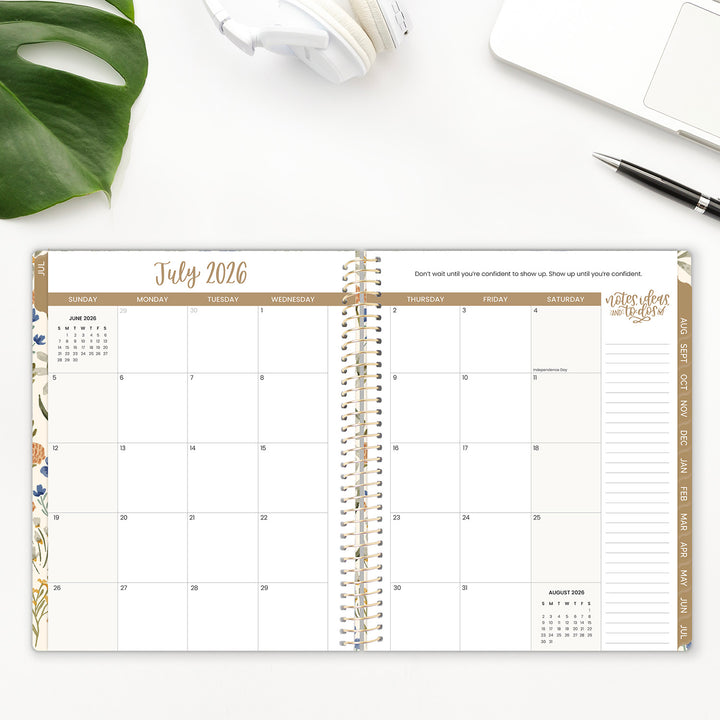 Spiral-bound planner open to July 2026 with a pen and plant on a white surface