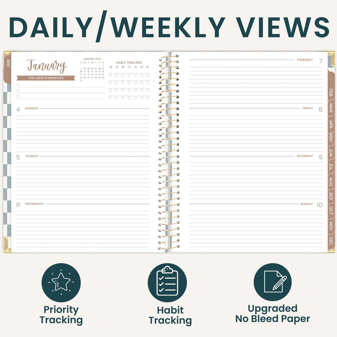 An open spiral-bound planner shown on a light beige background with the heading 'DAILY/WEEKLY VIEWS' at the top. The planner pages display a January weekly layout with columns for Monday through Sunday, habit tracker rows, and date fields.