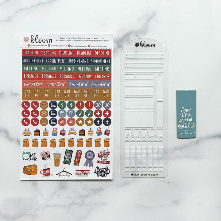 Bloom planner sticker and layout set on a white marble background, featuring a sticker sheet with colorful text and icon stickers, a white planner template sheet, and a small teal sticky note.