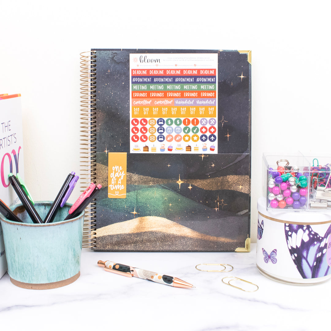 Planner with colorful stickers on a desk with stationery items