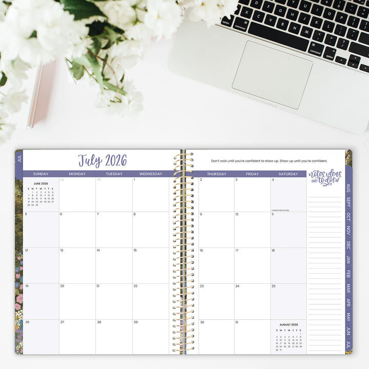 Open planner showing July 2026 with a laptop and flowers in the background