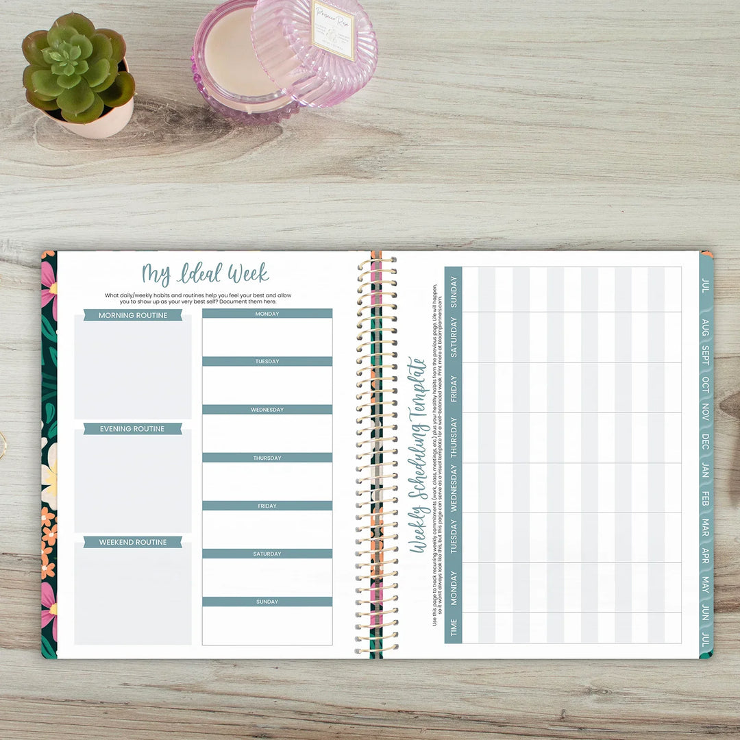 Open planner on a wooden surface with floral and grid designs