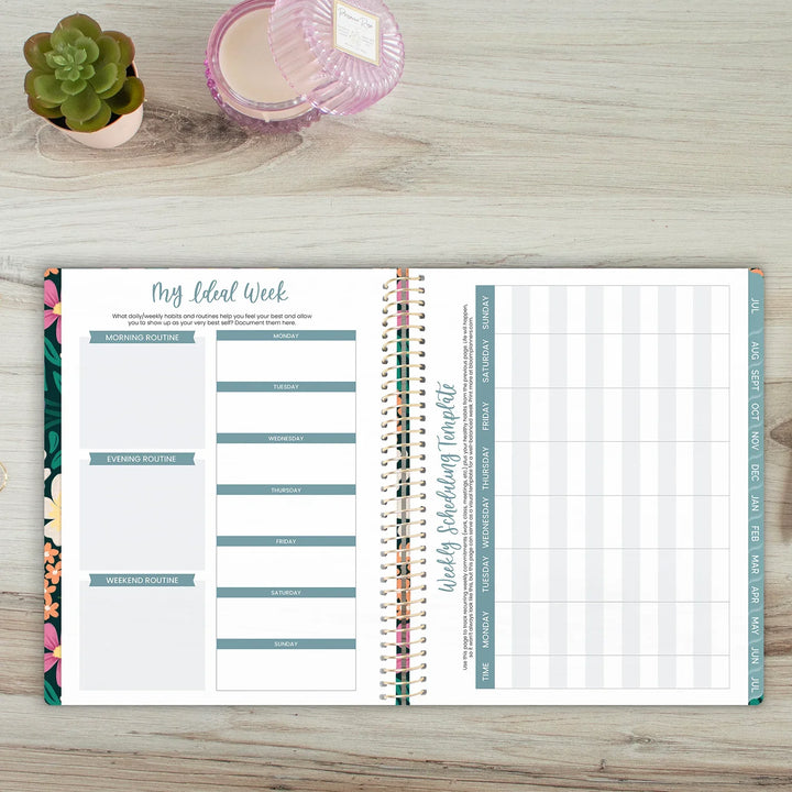 Open planner on a wooden surface with floral and grid designs