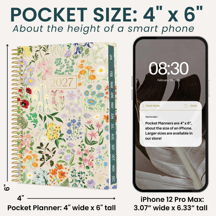 A pocket size 2027 floral planner shown next to an iPhone 12 Pro Max for size comparison. The planner features a colorful wildflower pattern on a cream background with a gold spiral binding and a green tabbed index spine.