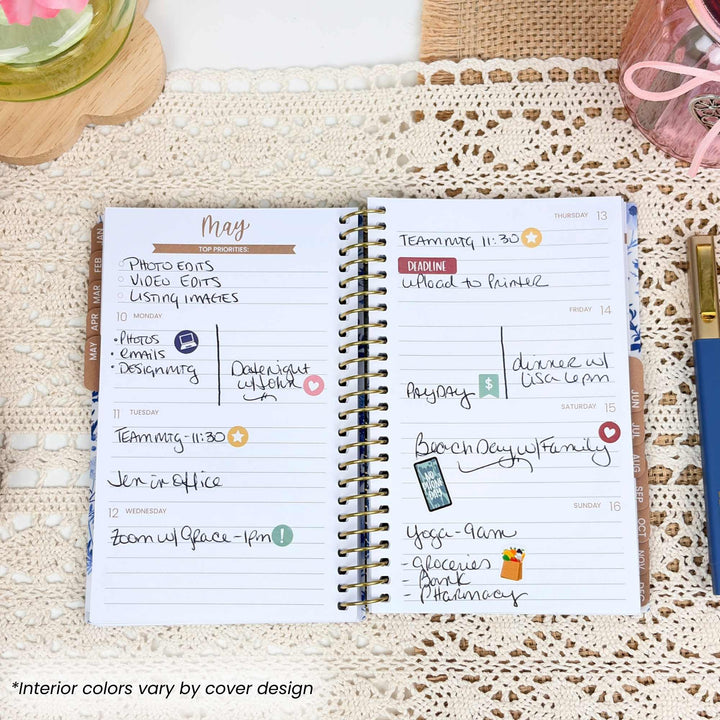 Planner open to a page with May monthly layout on a textured surface.