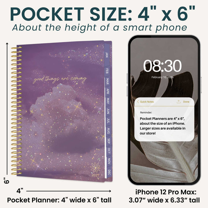 A pocket size spiral notebook planner shown next to an iPhone 12 Pro Max for size comparison. The notebook cover features a purple galaxy cloud design with gold glitter accents and gold spiral binding.