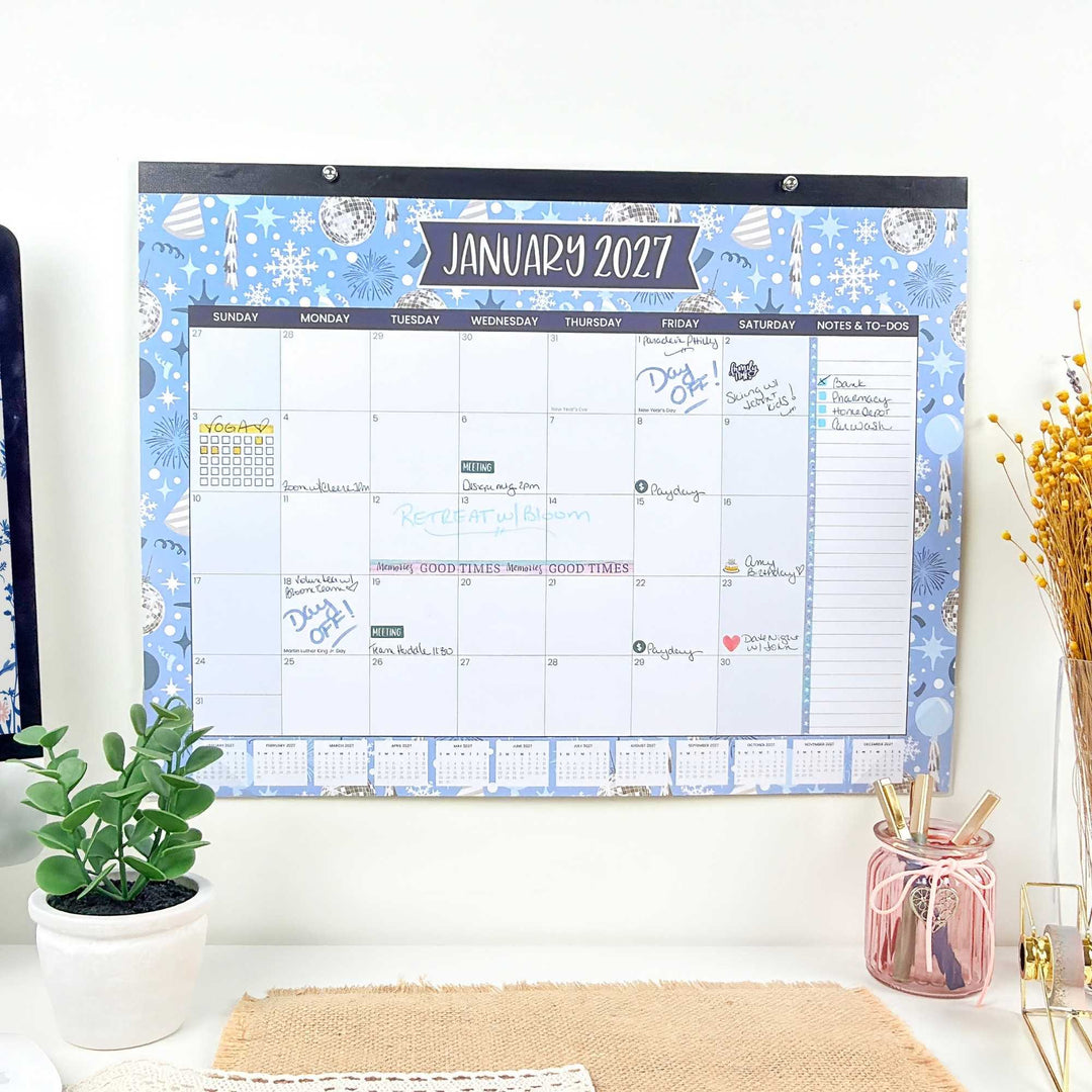 Wall calendar for January 2027 with decorative elements on a white wall.
