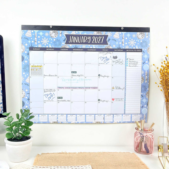 Wall calendar for January 2027 with decorative elements on a white wall.