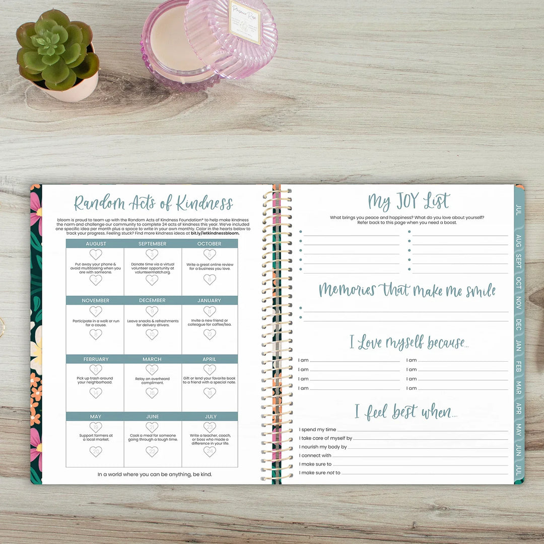 Open planner on a wooden surface with 'Random Acts of Kindness' and 'My JOY List' sections.