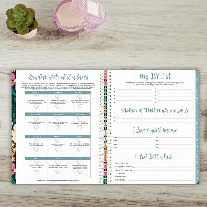Open planner on a wooden surface with 'Random Acts of Kindness' and 'My JOY List' sections.