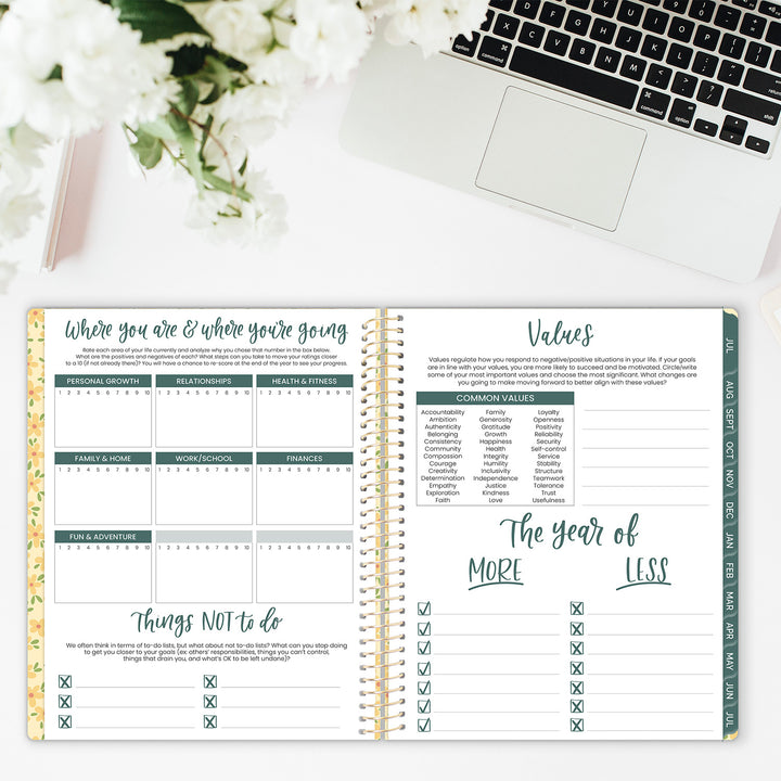 Open planner with checklists and sections on a desk with a laptop and flowers.