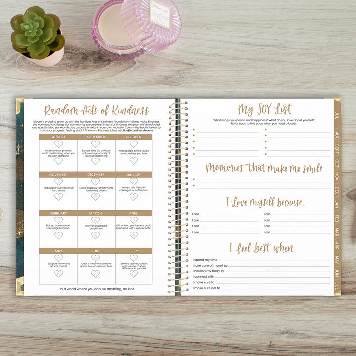 Open planner on a wooden surface with 'Random Acts of Kindness' and 'My JOY List' sections.