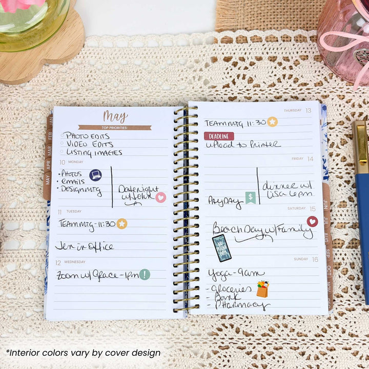 Planner open to a page with May monthly layout on a textured surface.