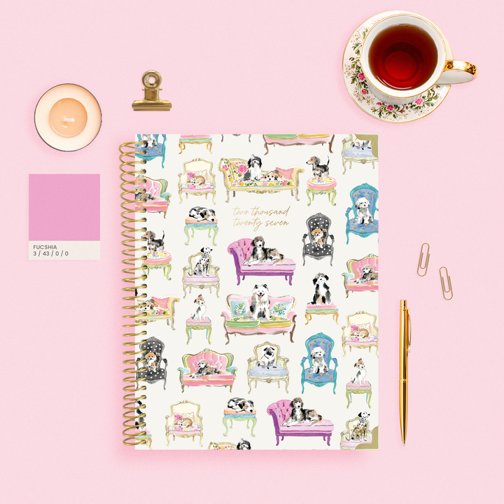 Sit Stay Plan 2027 Planner on a pink background styled with pens, paper clips, and a cup of tea.