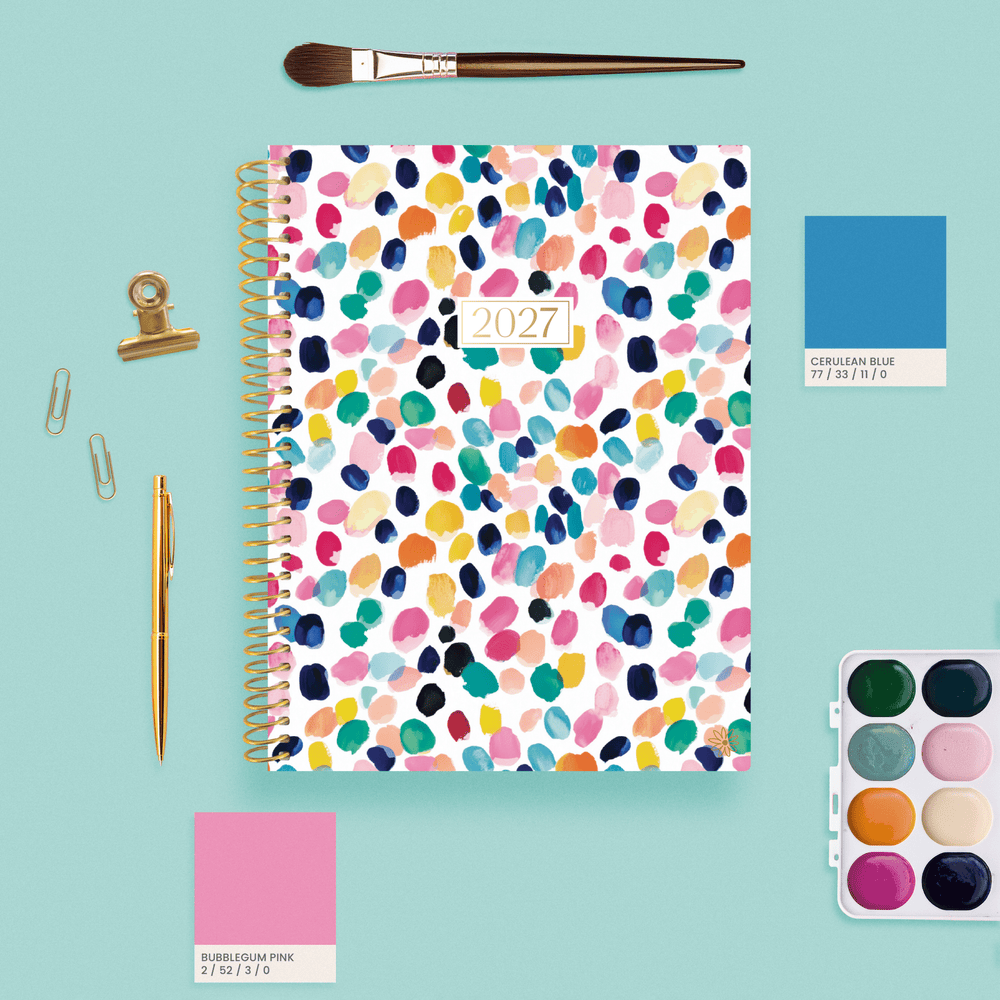 2027 Confetti bloom planner on a teal background surrounded by pain, brushes and pantone swatches. - hover