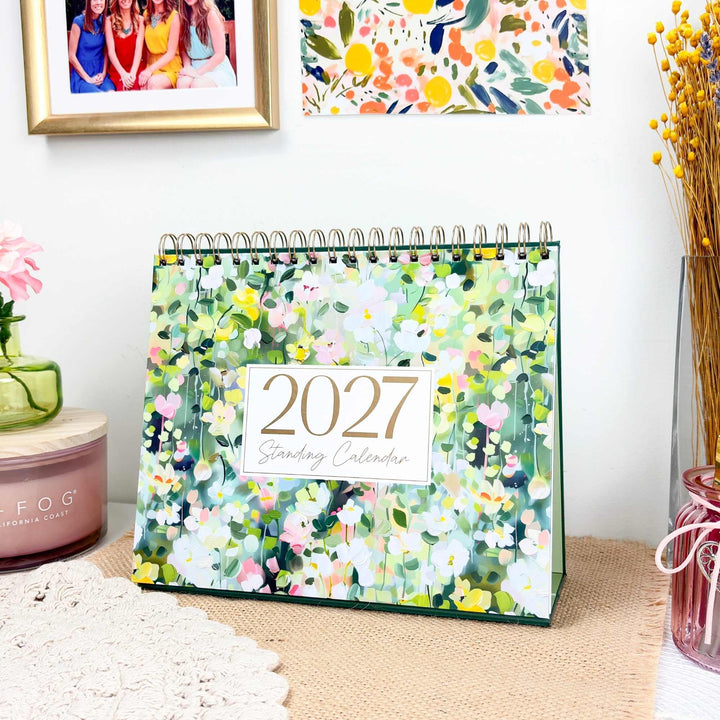 2027 bloom Standing Desk Calendar displayed on a home desk with candle and wall art.
