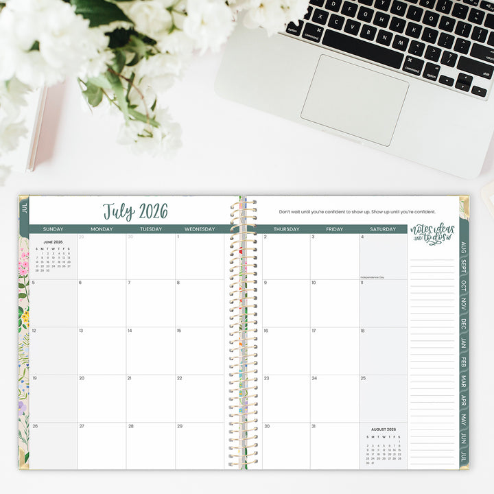 Open planner showing July 2026 with a laptop and flowers in the background