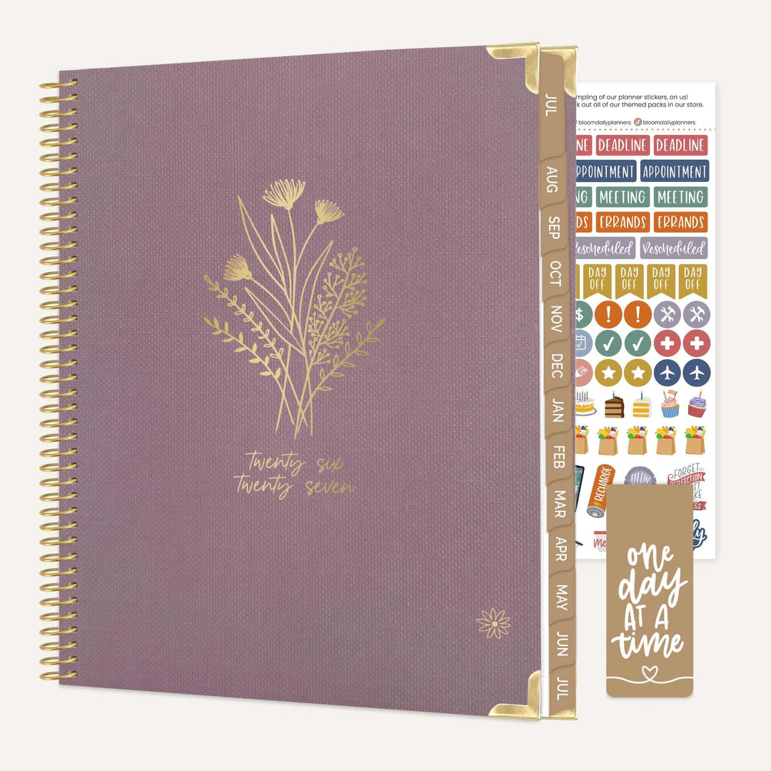 Purple planner with gold floral design and additional stickers on a white background