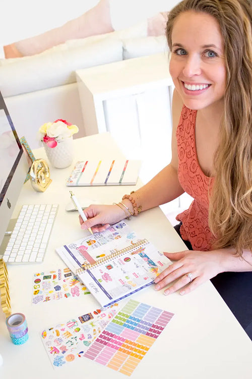 girl sitting at desk with planner smiling
