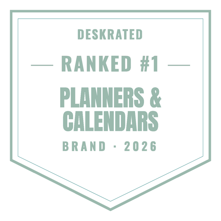 A mint green shield-shaped badge with text reading 'DESKRATED RANKED #1 PLANNERS & CALENDARS BRAND • 2026' on a white background.